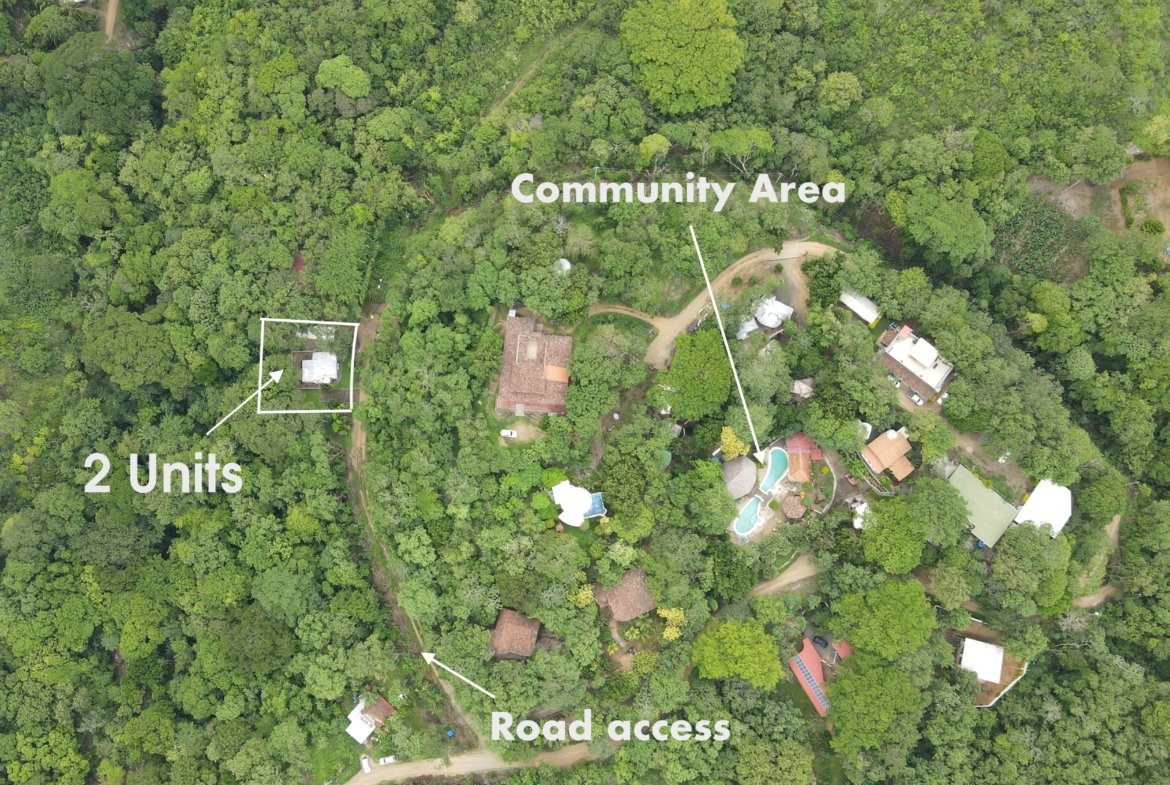 Aerial drone view of property for sale in San Juan del Sur with two homes, green common area and access road in the Camino del Sol gated community