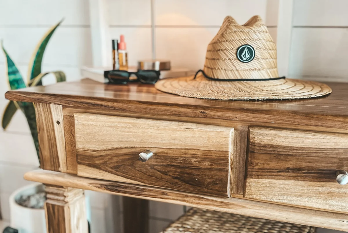 Straw hat and sunglasses on a bedside table inside a bungalow at Monoloko Lodge, Popoyo, Nicaragua