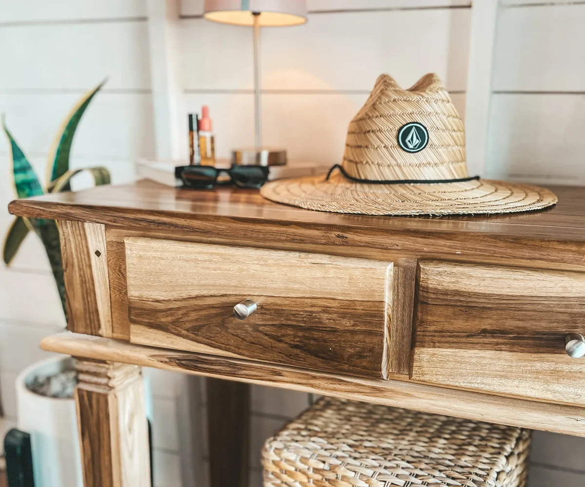 Straw hat and sunglasses on a bedside table inside a bungalow at Monoloko Lodge, Popoyo, Nicaragua