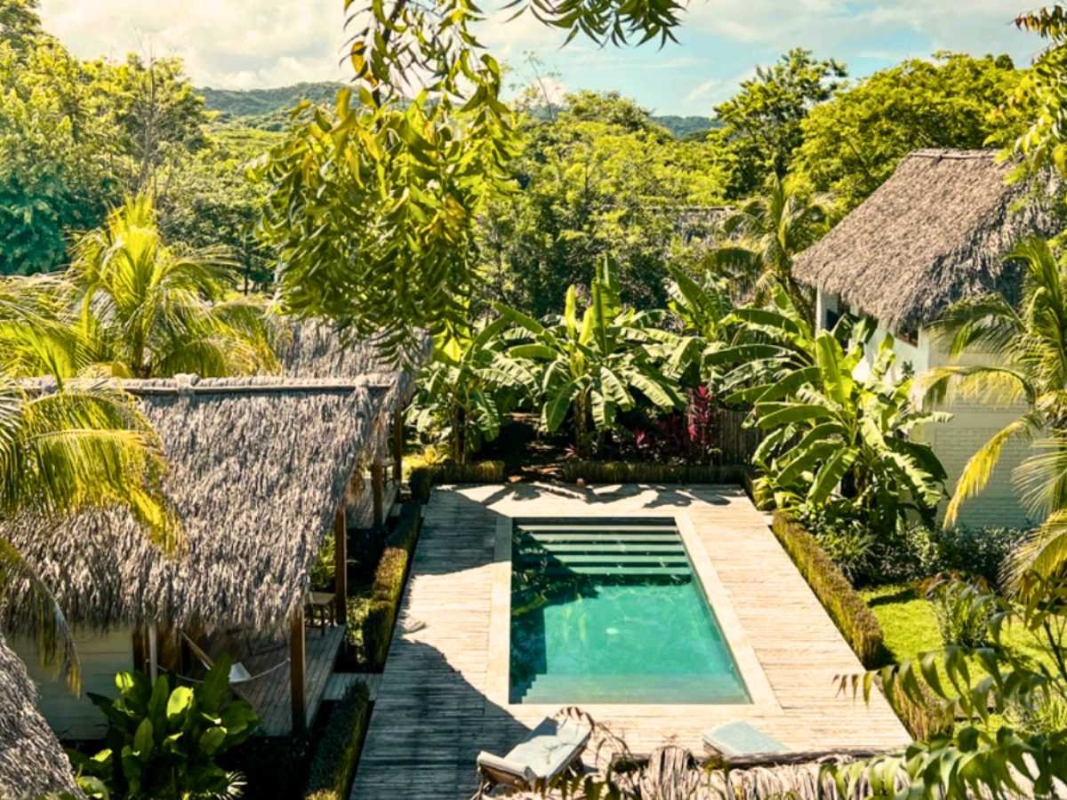 Swimming pool surrounded by tropical gardens at Monoloko Lodge, a surf lodge for sale near Playa Santana, Nicaragua
