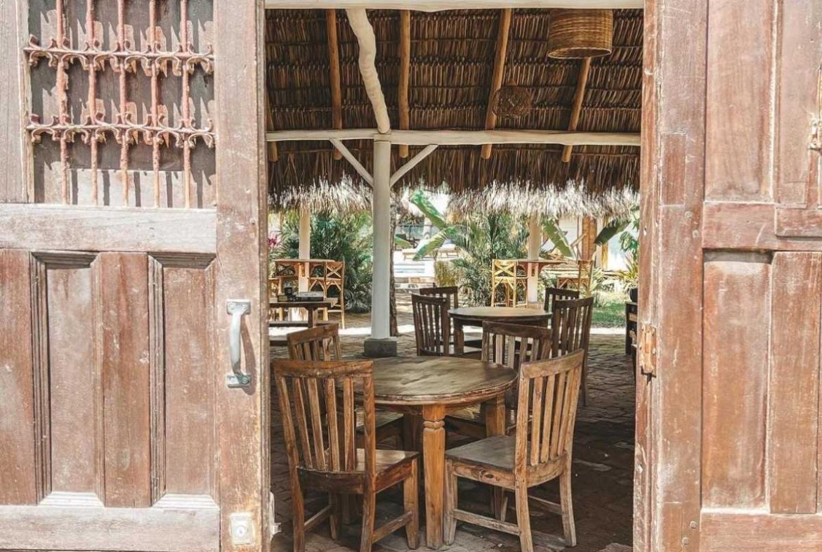 Entrance to the open-air restaurant with tables and chairs at Monoloko Lodge, an operating surf lodge for sale in Popoyo, Nicaragua