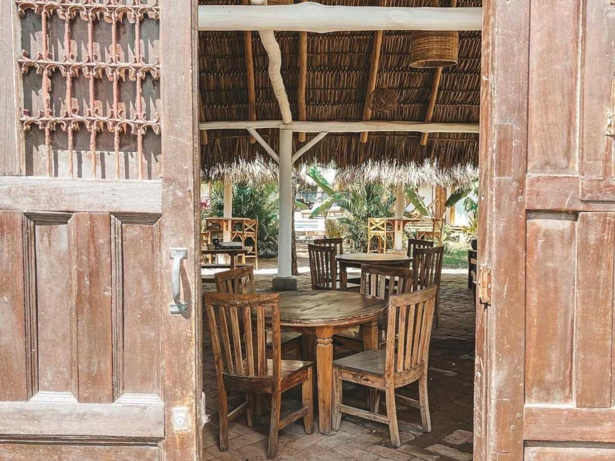 Entrance to the open-air restaurant with tables and chairs at Monoloko Lodge, an operating surf lodge for sale in Popoyo, Nicaragua