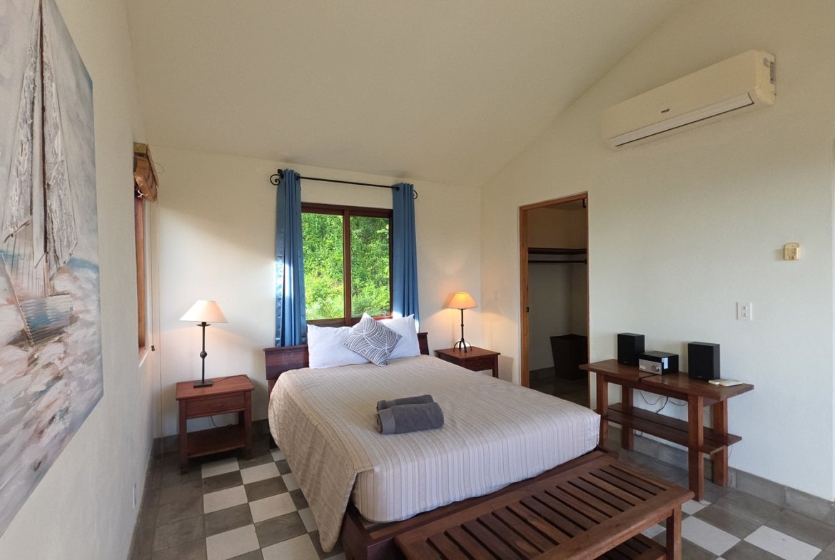 Master bedroom with wooden furniture and ceiling fan at Villas de Palermo, San Juan del Sur